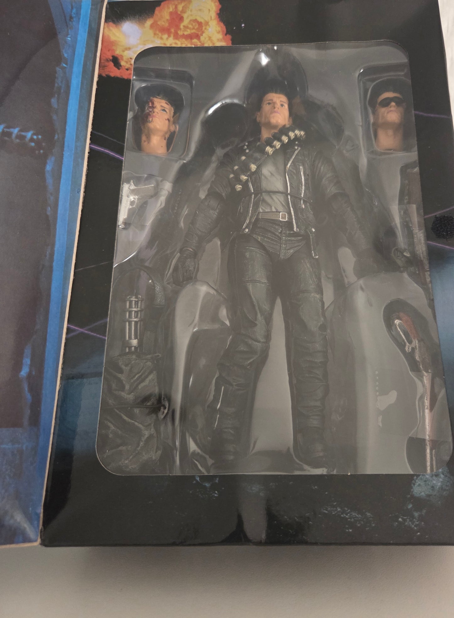 Figurine T-800 NECA Terminator 2 dans son blister ouvert – vue d'ensemble avec les 3 têtes interchangeables et accessoires